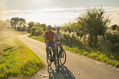 Zwei Radfahrende im Gegenlicht