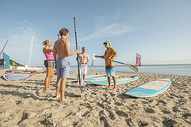 Eine Gruppe von SUPern an der Ostsee am Strand