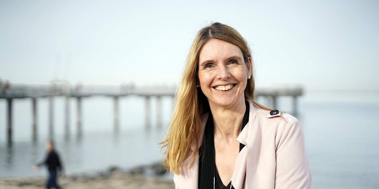 Krimi-Autorin Eva Almstädt steht am Ostseestrand