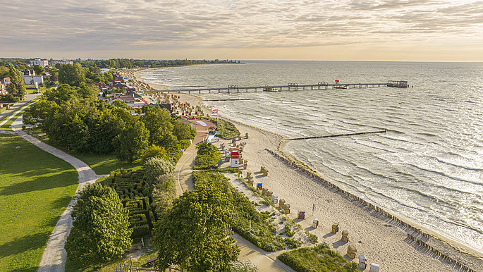 Kellenhusen an der Ostsee von oben. Ein Blick auf das Meer, dahinter viel grün.