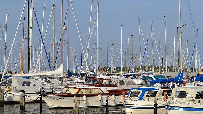 Auf dem Bild sind viele Segelboote, die im Hafen stehen zu sehen.