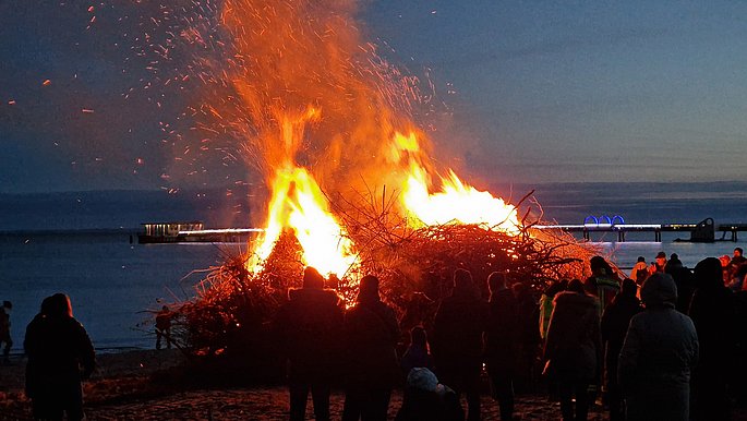 Eine Veransaltung am dunklen Ostseestrand mit Feuer. 