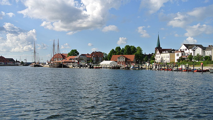 Viel Wasser im Bild, im Hintergrund zeichnet sich ein Hafen ab.
