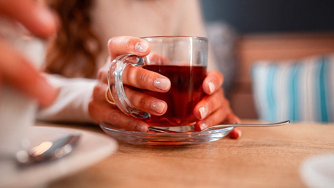 Lachendes Paar im Bootshaus Café, entspannter Moment bei Tee an der Ostsee Schleswig-Holstein genießen. 