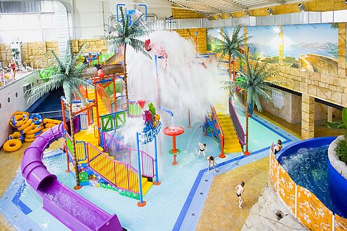 Bunte Rutschen und Wasser in einer Schwimmhalle.
