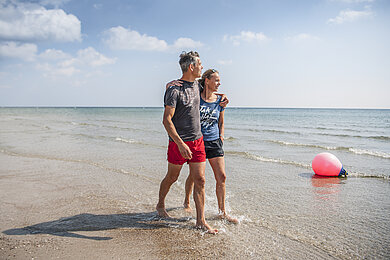 Paar spaziert am Strand in Damp
