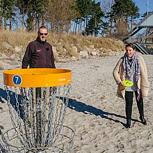 Heiko Behrens und Ostseelauschen-Moderatorin Simone spielen Disk-Golf.