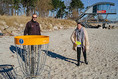 Heiko Behrens und Ostseelauschen-Moderatorin Simone spielen Disk-Golf.