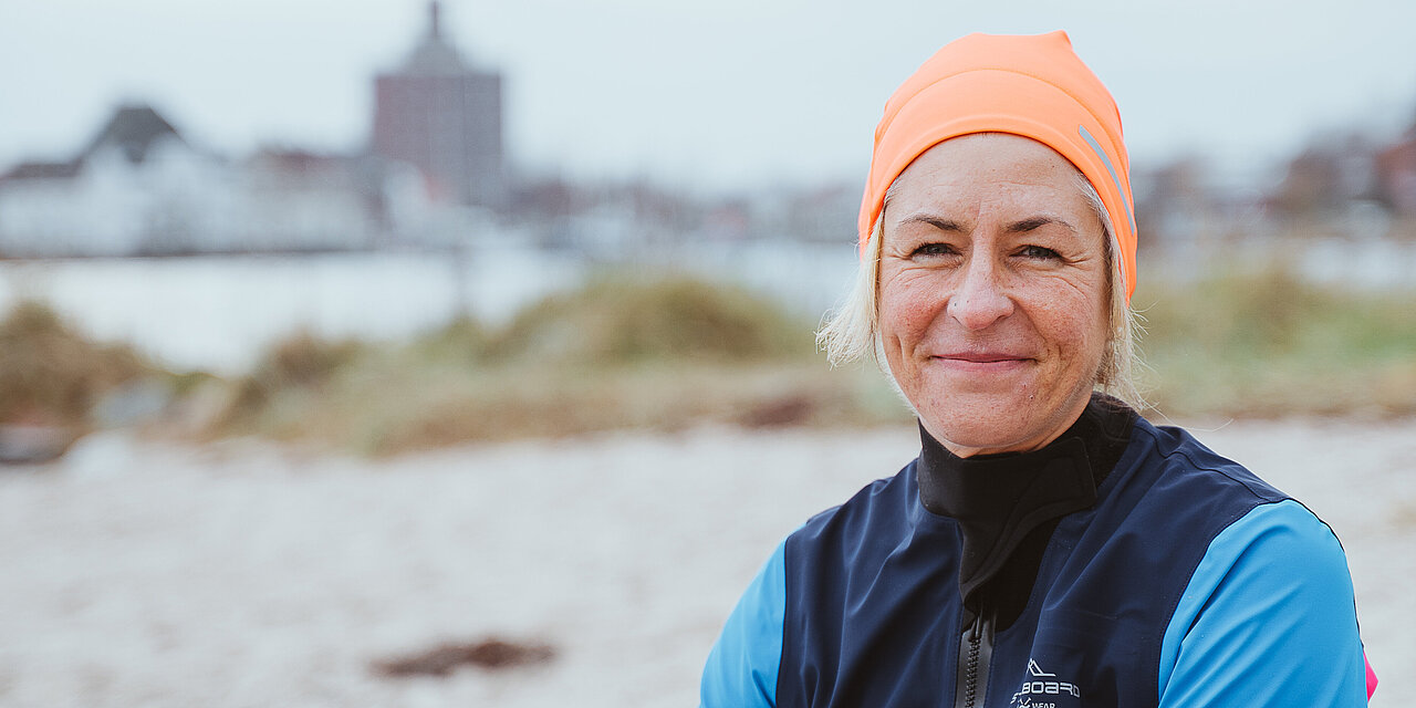 Eine Frau mit orangener Badekappe an der Ostsee