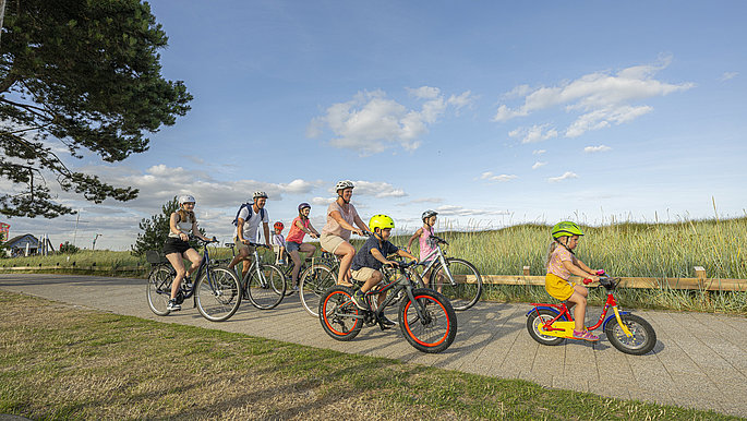 Eine Gruppe, die in der Jugendherberge Scharbeutz Urlaub macht, fährt mit den Fahrrändern an der Küste entlang.