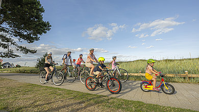 Eine Gruppe, die in der Jugendherberge Scharbeutz Urlaub macht, fährt mit den Fahrrändern an der Küste entlang.