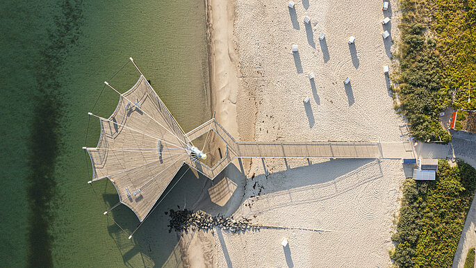 Luftbildaufnahme von der Seebrücke in Hohwacht. Form der Seebrücke gleicht einer Flunder