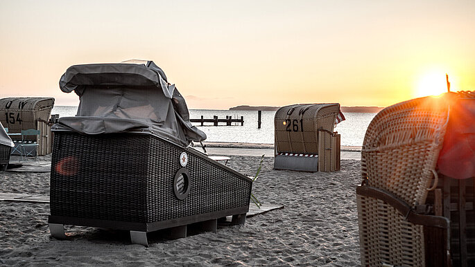 Schlafstrandkörbe von hinten am Strand, Blick aufs Meer,