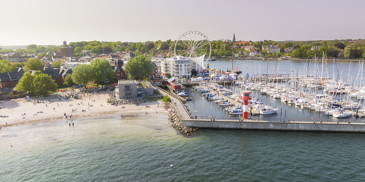 Luftbild vom Hafen. Am Hafen schlendern, entlang der großen Traditionssegler bummeln oder einen Kaffee im Restaurant trinken, mit Blick aufs Wasser. 