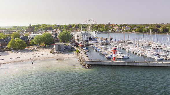 Luftbild vom Hafen. Am Hafen schlendern, entlang der großen Traditionssegler bummeln oder einen Kaffee im Restaurant trinken, mit Blick aufs Wasser. 