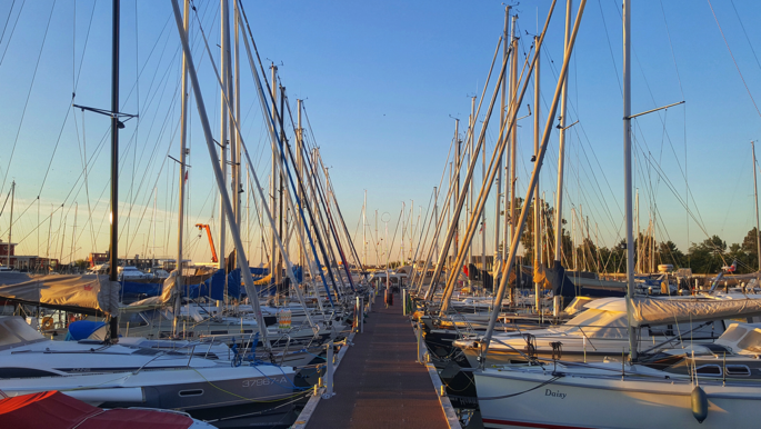 Ein Steg mit anliegenden Yachten im Hafen. 