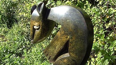 Ein Kunstwerk aus Bronze oder einer ähnlichen Substanz, ähnelt einem Eichhörnchen. 