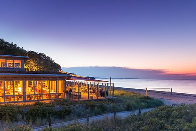 Restaurant Bootshaus mit großer Terrasse, die Meeresbrise und die strahlenden Sonnenuntergänge. Liegt direkt am Naturstrand und der weite Blick über das Meer, bilden im Restaurant Bootshaus die perfekte Kulisse für unvergessliche Erinnerungen.