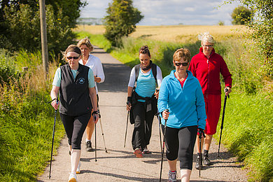 Eine Gruppe geht mit ihrer Nordic Walking Ausrüstung durch die Natur von Heiligenhafen