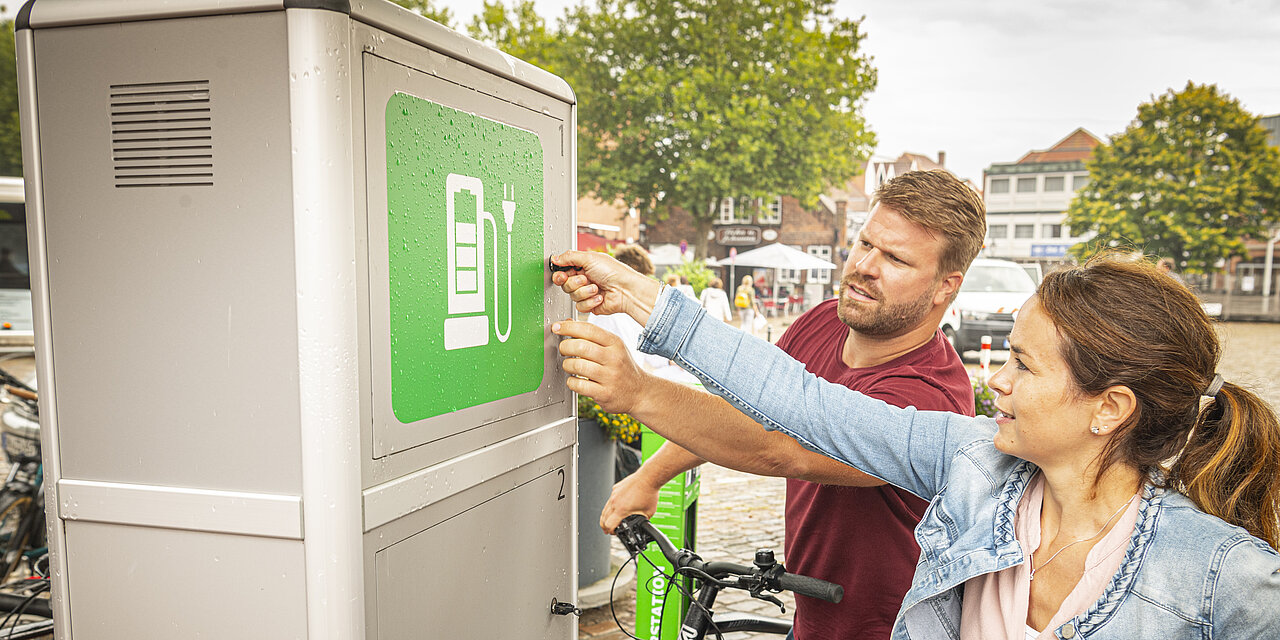 Paar steht an einer E-Bike-Ladestation