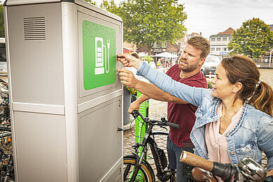 Paar steht an einer E-Bike-Ladestation