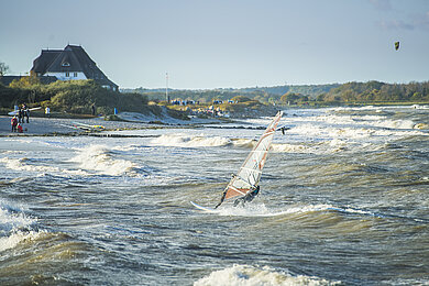 Ein Windsurfer reitet die Wellen an der Ostsee 