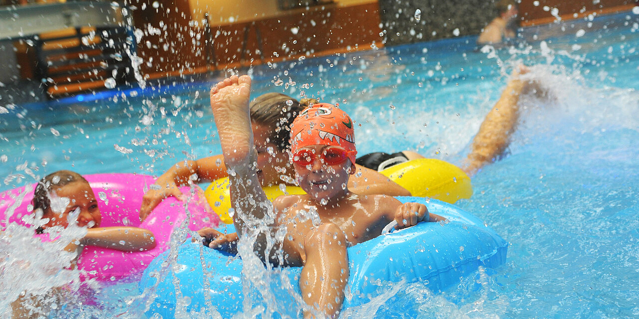 Kinder im Schwimmreifen im Schwimmbecken.