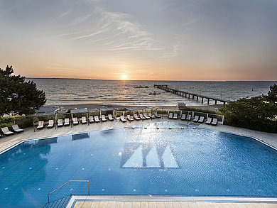 Mit Blick (höhere Standpunkt im Hotel) auf die Außenanlage, den Pool, und die Ostsee mit der Seebrücke.