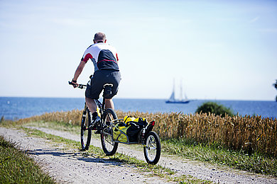 Ein Mann fährt auf einen Radweg Fahrrad. 