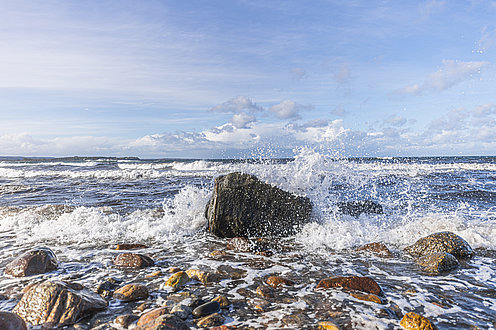 Wellen zerschlagen an den Felsen am Ostsee Strand in Wangels.