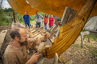 Ein Bootsbauer baut ein Holzboot mit der Hand, so wie es früher gemacht wurde