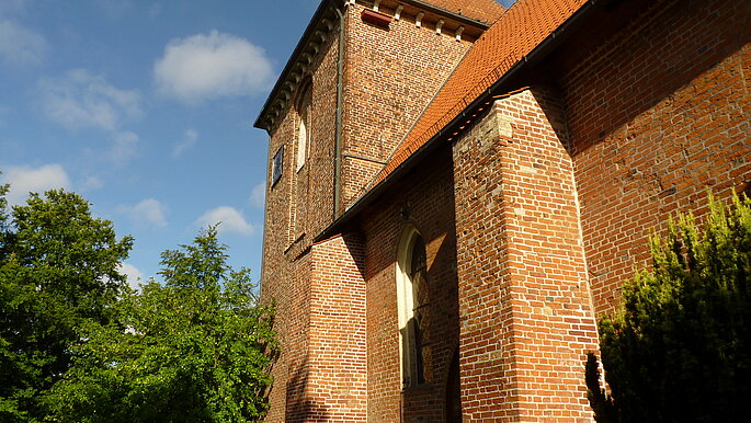Eine Kirche von der Seite, schräg unten. Ein Bau aus Backsteinen. 