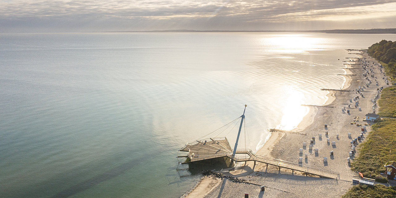 Luftbildaufnahme der Seebrücke "Flunder" in Hohwacht, der Landschaft und der Ostsee.