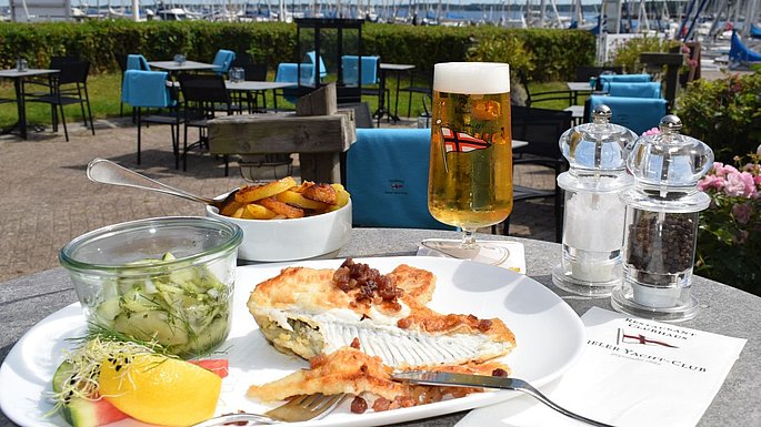 Gericht im Restaurant in Strande. Auf dem Teller ist ein Fischgericht angerichtet.
