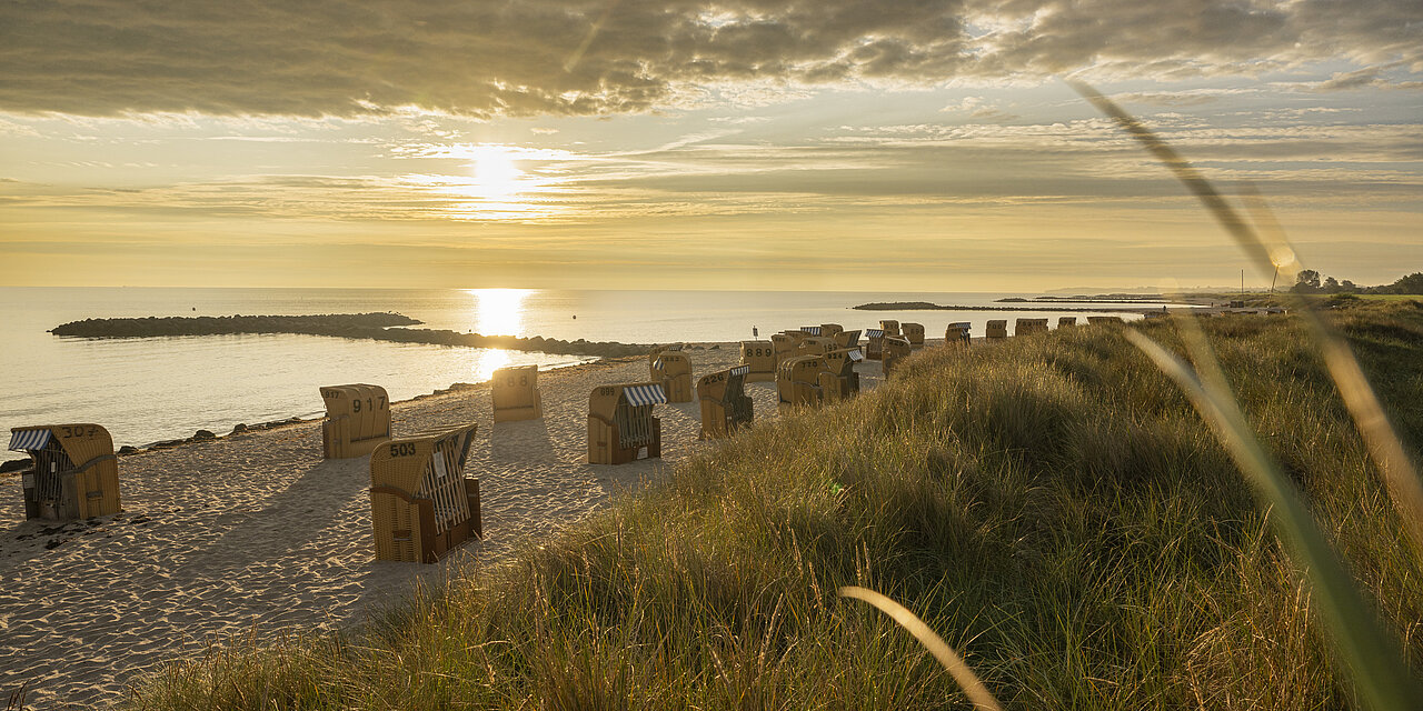 Blick auf den Sonnenuntergang am Strand in Schönberg, im rötlichen Abendlicht.