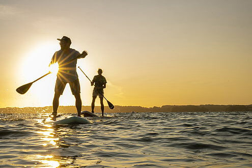 Stand Up Paddler auf der Ostsee im Sonnenuntergang